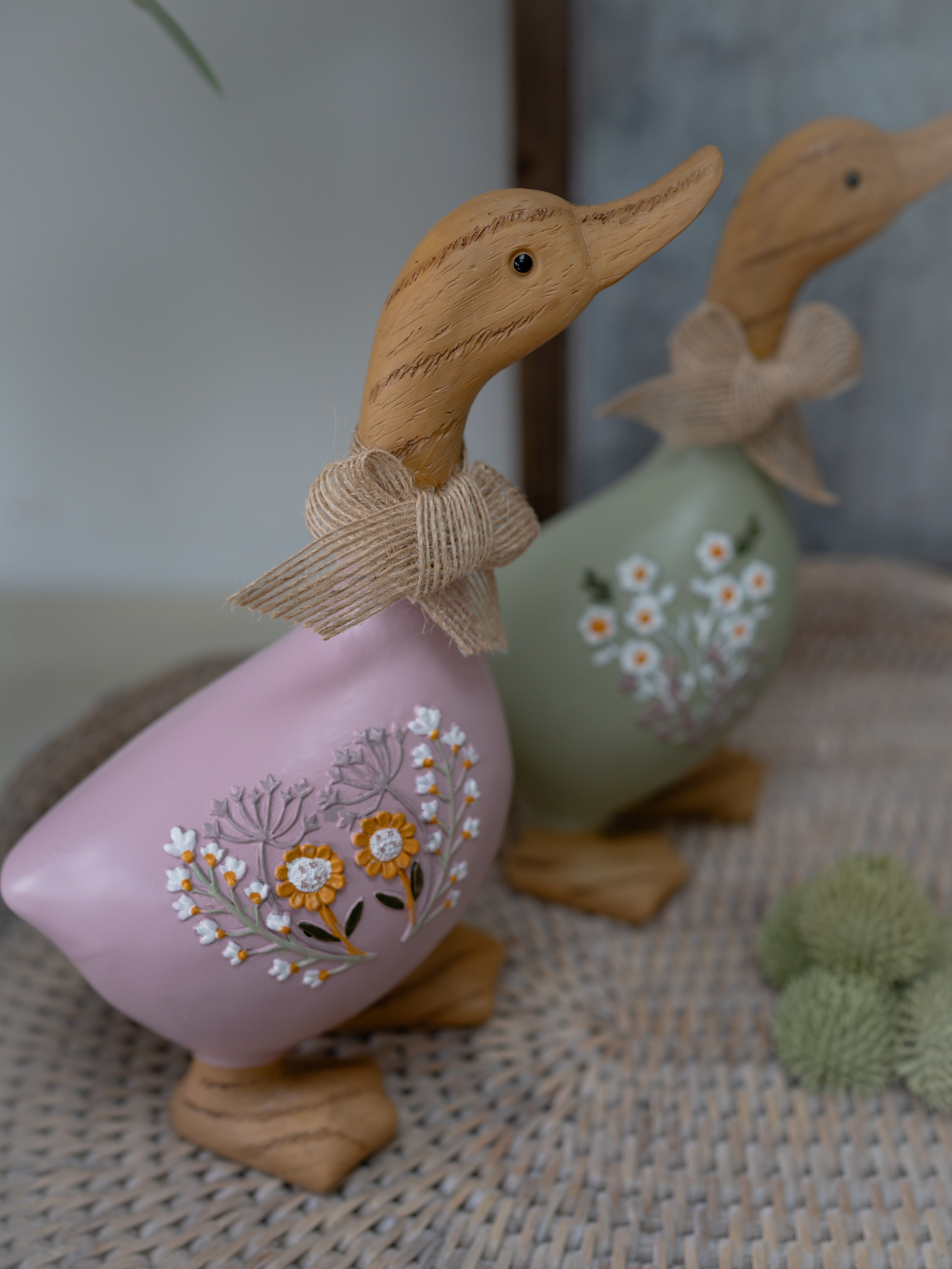 Decorative duck figurines with floral designs on a textured surface.