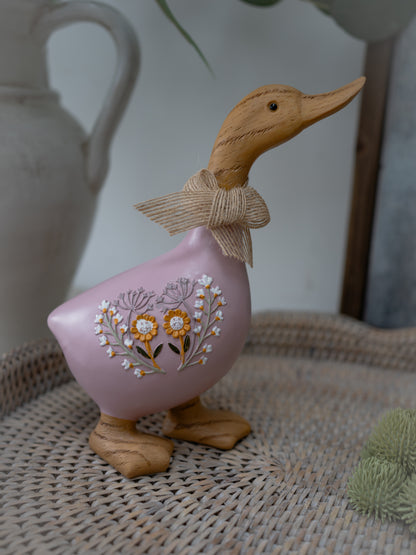 Decorative duck figurine with floral design on a woven surface