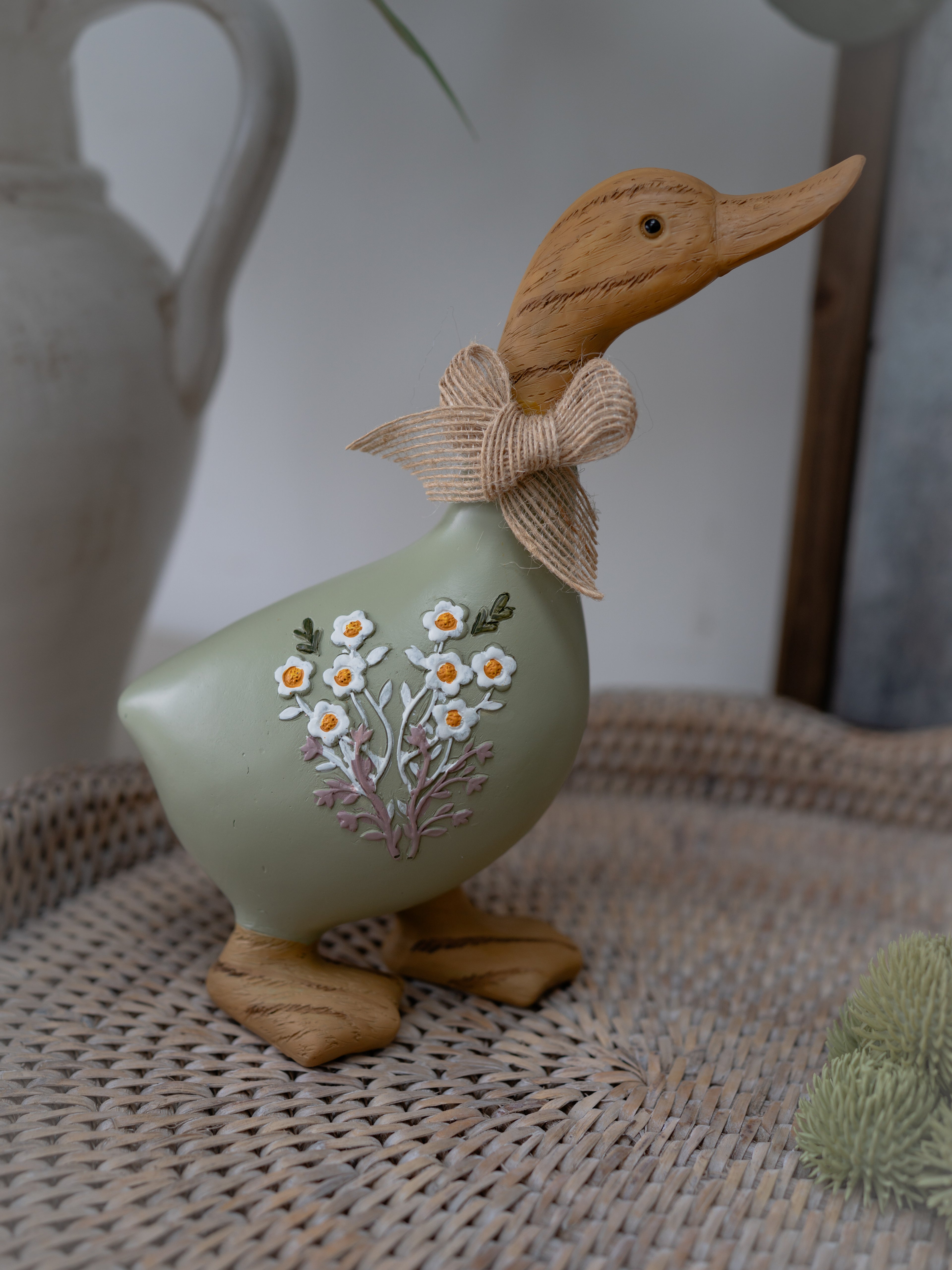 Decorative duck figurine with floral design on a woven surface