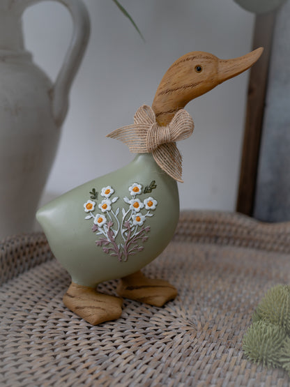 Decorative duck figurine with floral design on a woven surface