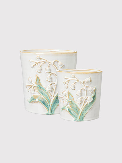 Two decorative ceramic pots with floral designs on a white background