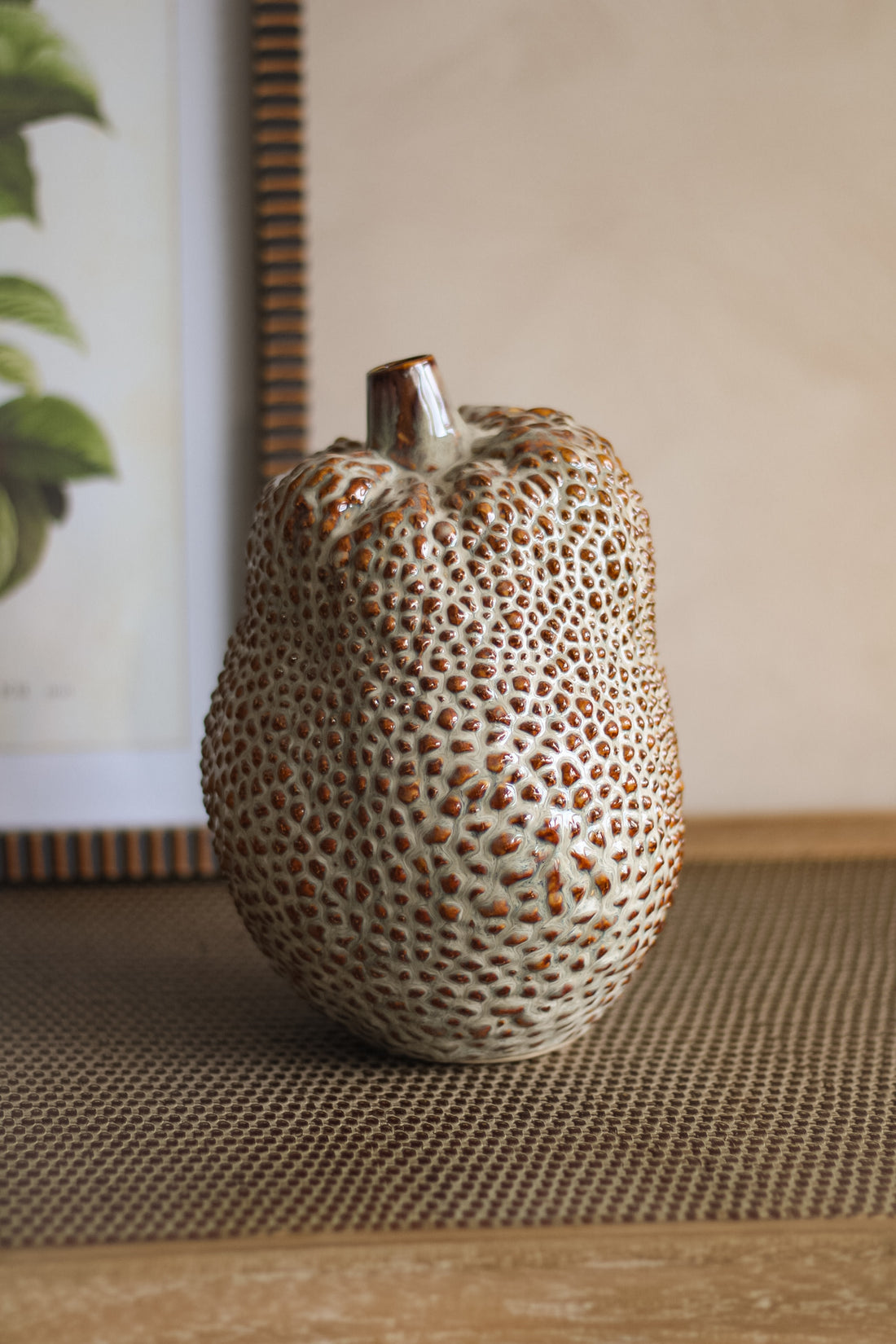 Decorative ceramic durian vase with textured surface on a woven mat