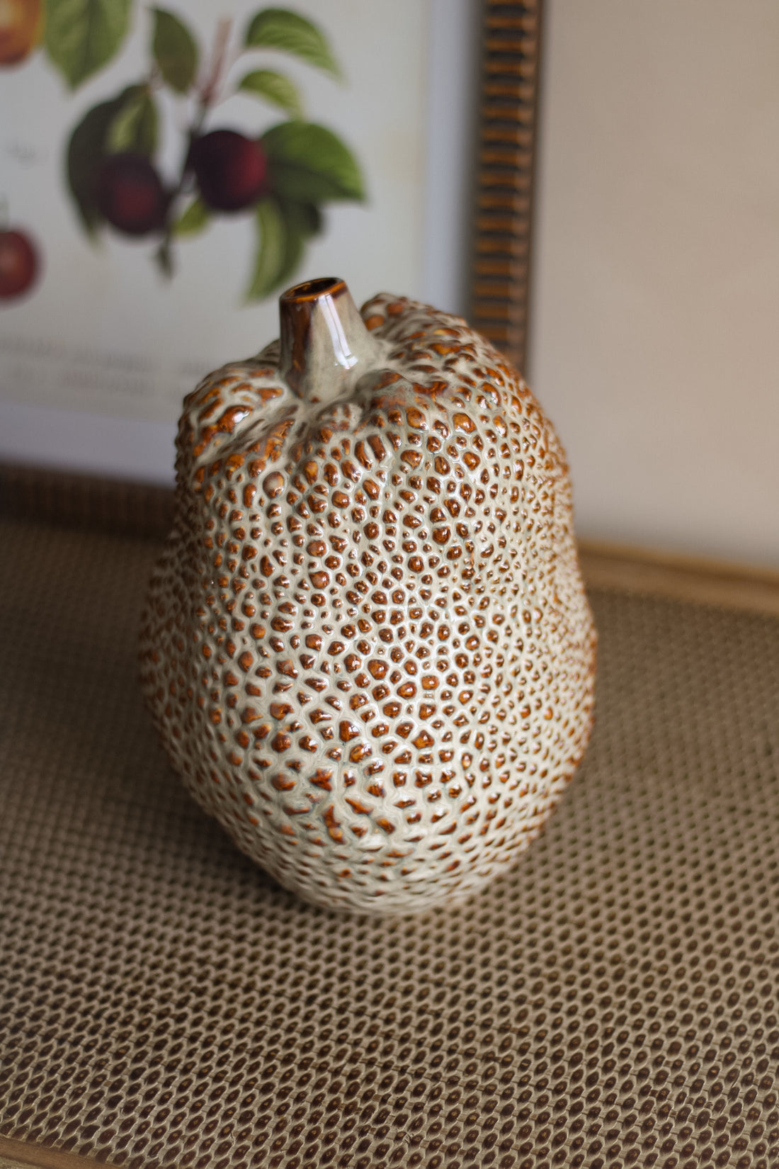 Decorative ceramic durian vase with textured surface on a textured surface