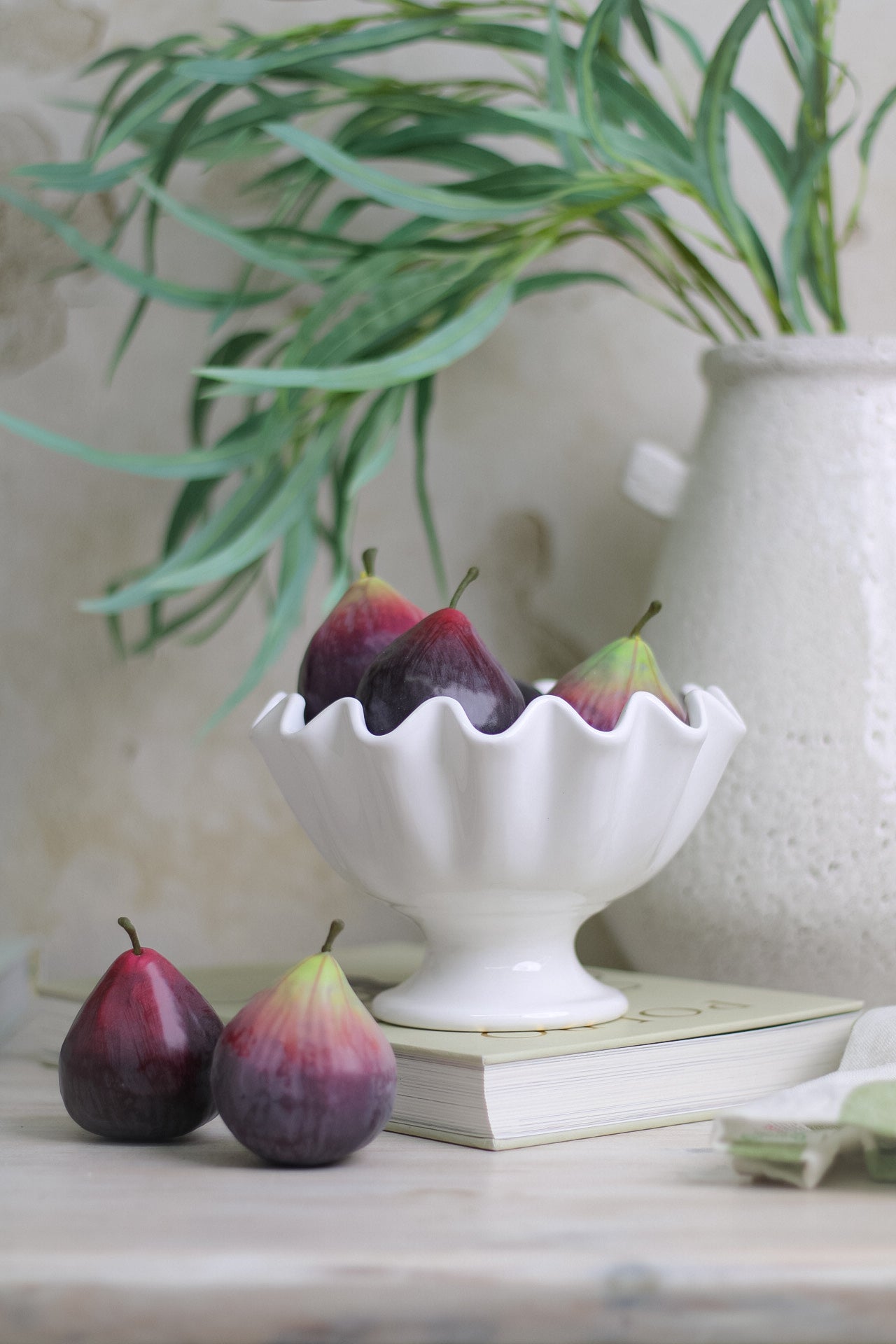 Decorative faux figs in white ruffled bowl