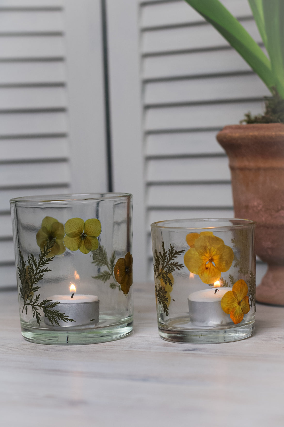 glass tea light holders with yellow flowers with lit tea light