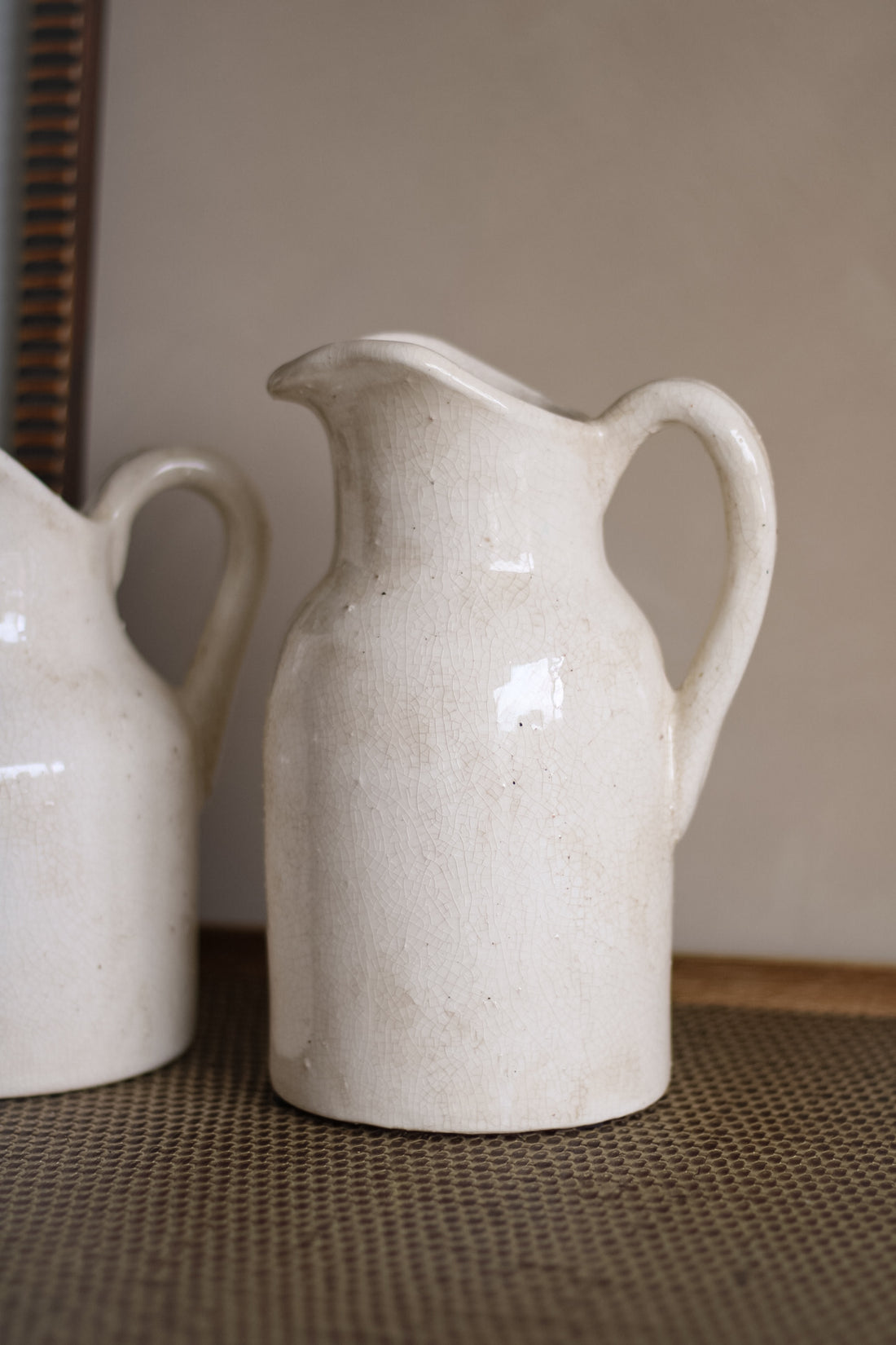 White ceramic pitcher on a textured surface with a neutral background
