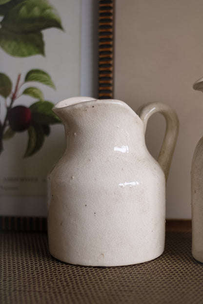 White ceramic pitcher on a textured surface with a blurred background