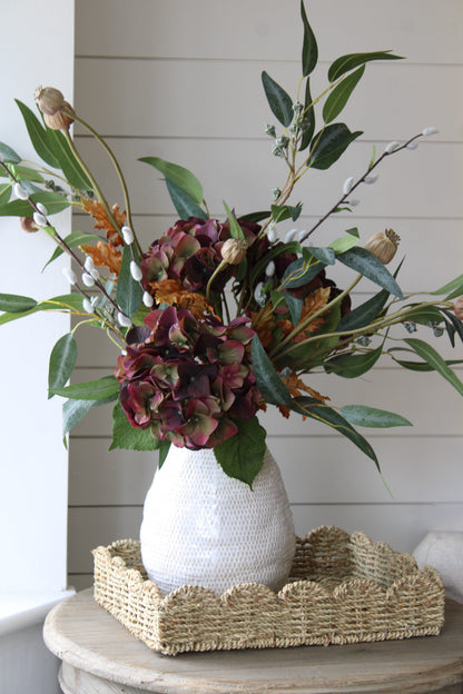 White textured vase with a Faux Autumn Hydrangea, Blush Poppy and Berry Eucalyptus Floral arrangement on a wooden surface