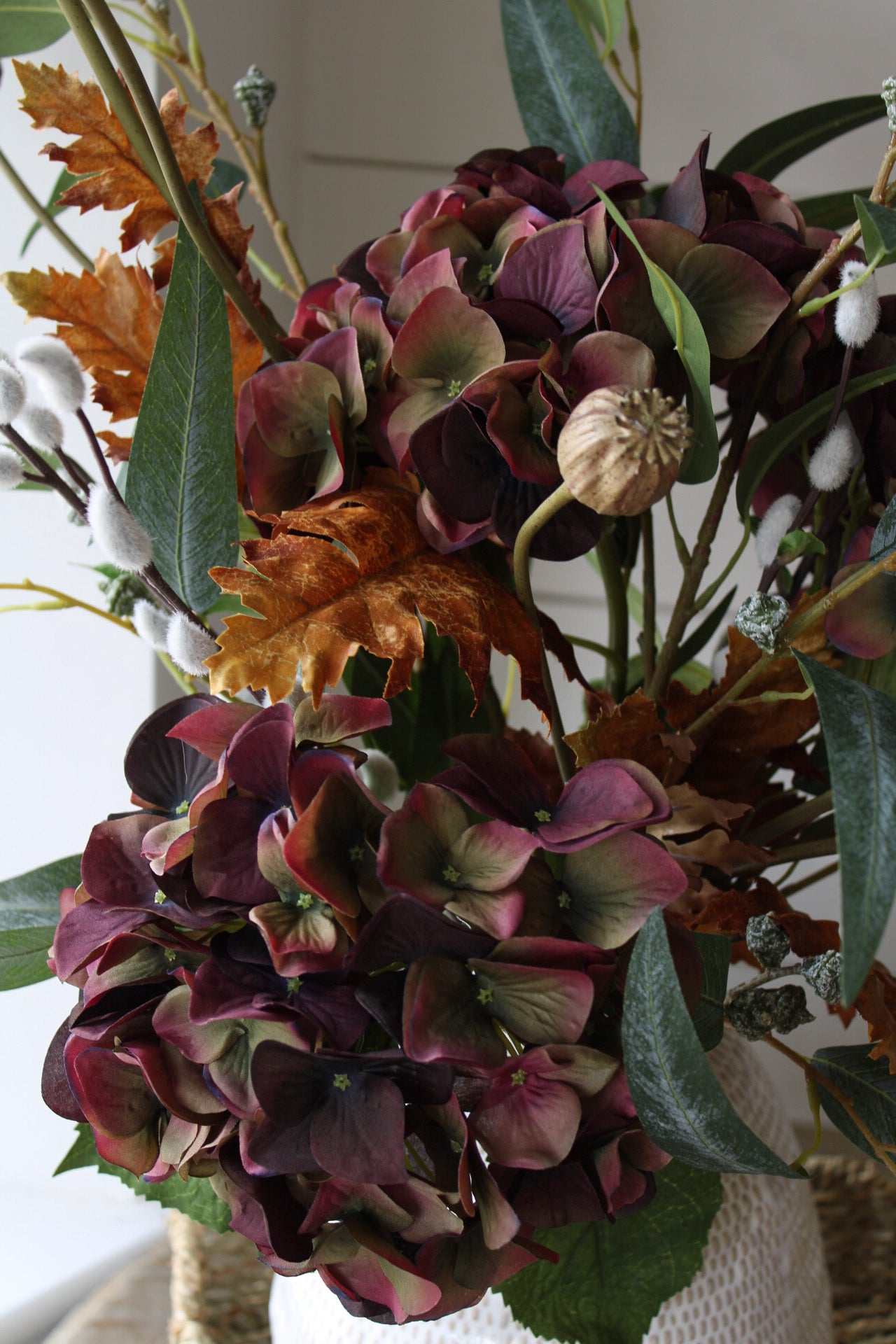 Bouquet of autumn flowers with purple and green hues in a vase.