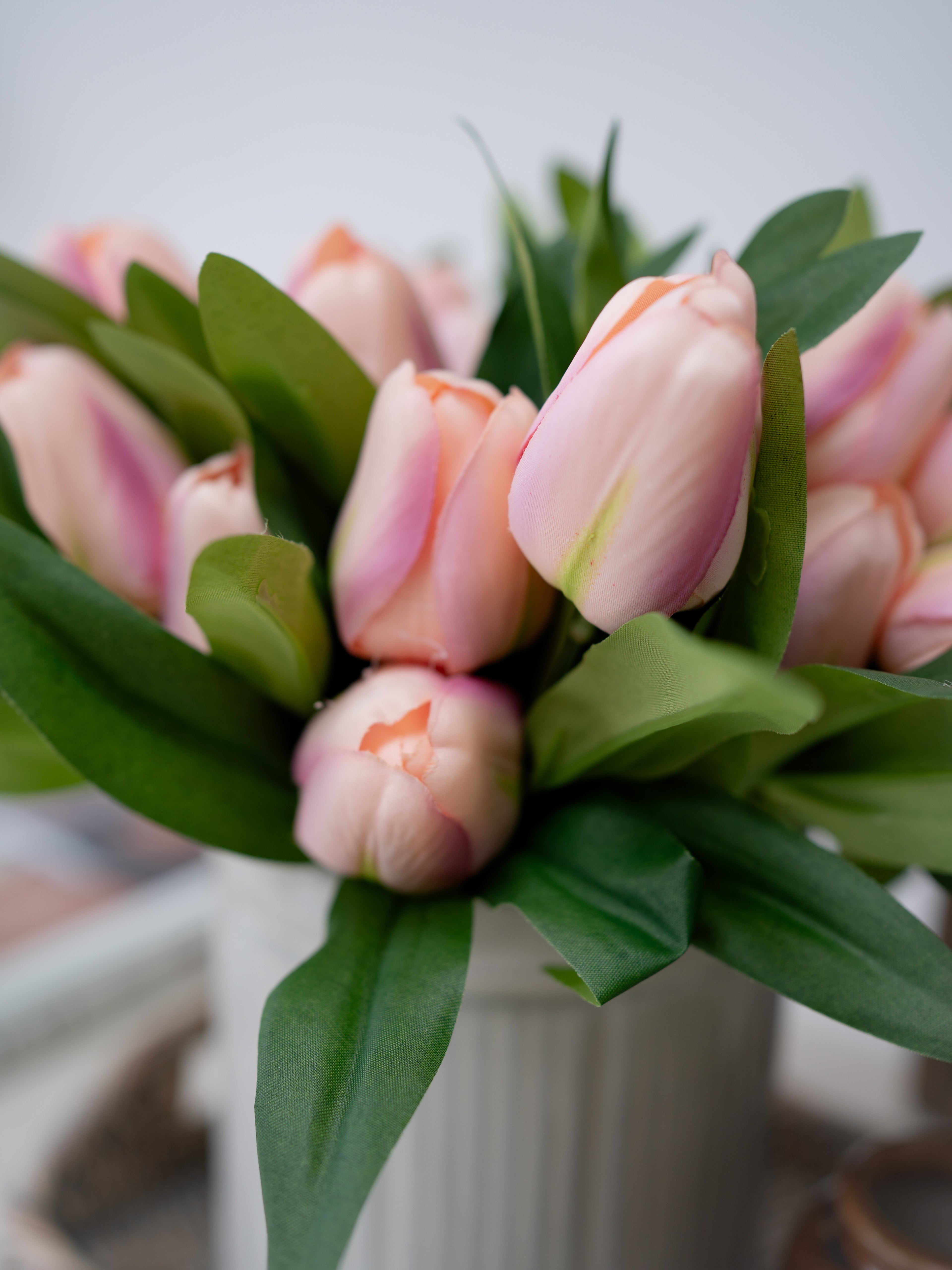 Bouquet of pink tulips with green leaves on a blurred background