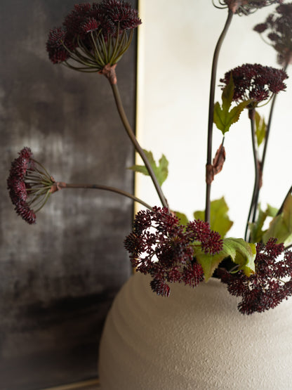 Vase with dried flowers against a blurred background
