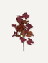 A single stem of artificial autumn leaves in shades of burgundy, rust, and brown, isolated on a light off-white background.