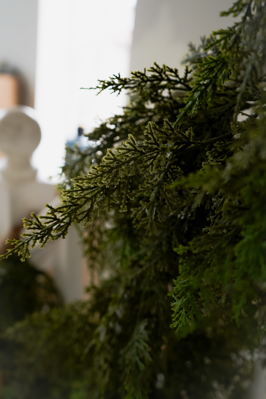 Close-up of faux green cypress foliage with a blurred background