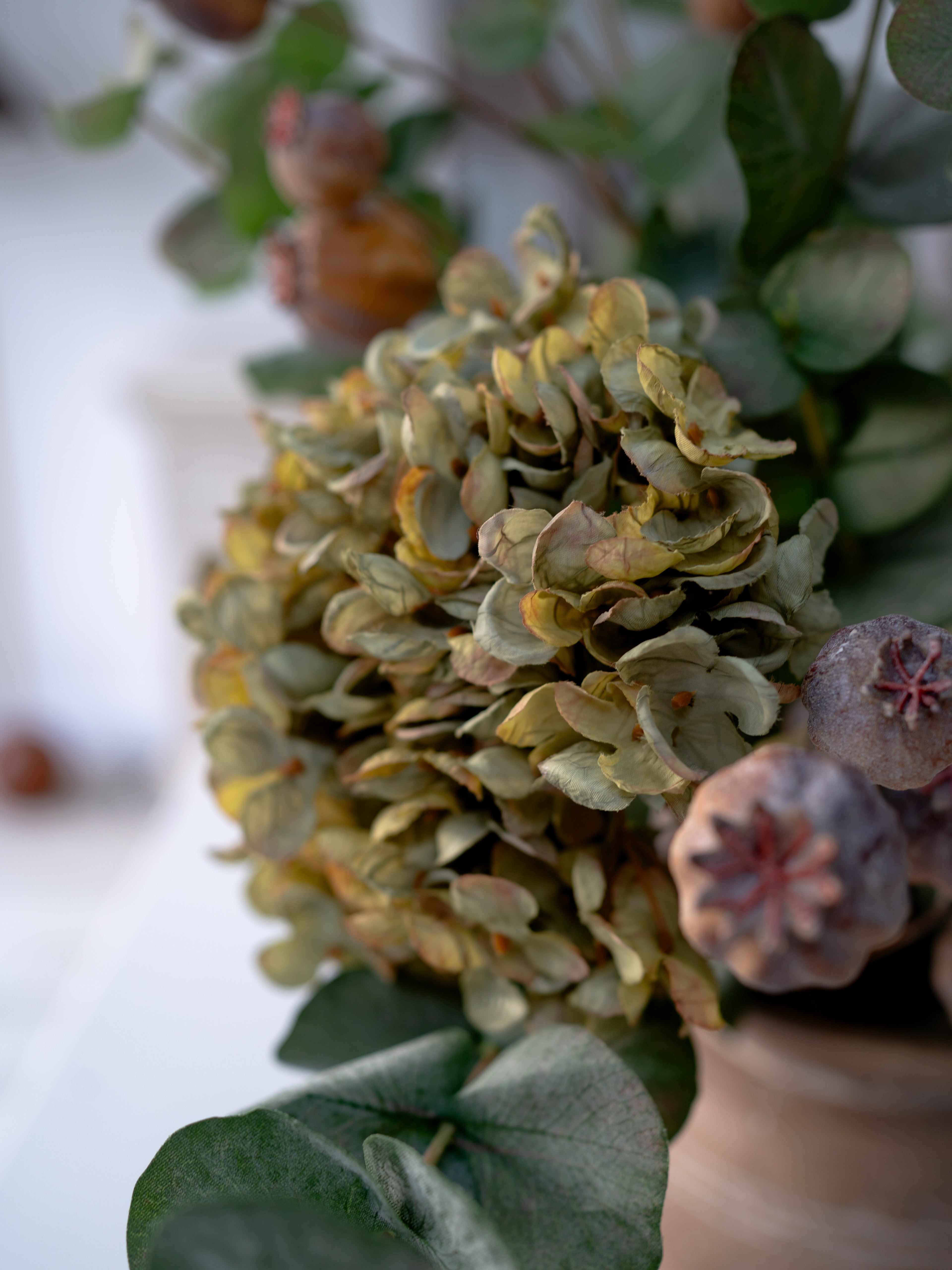 Close-up of a bouquet with green hydrangeas and brown flowers and leaves.