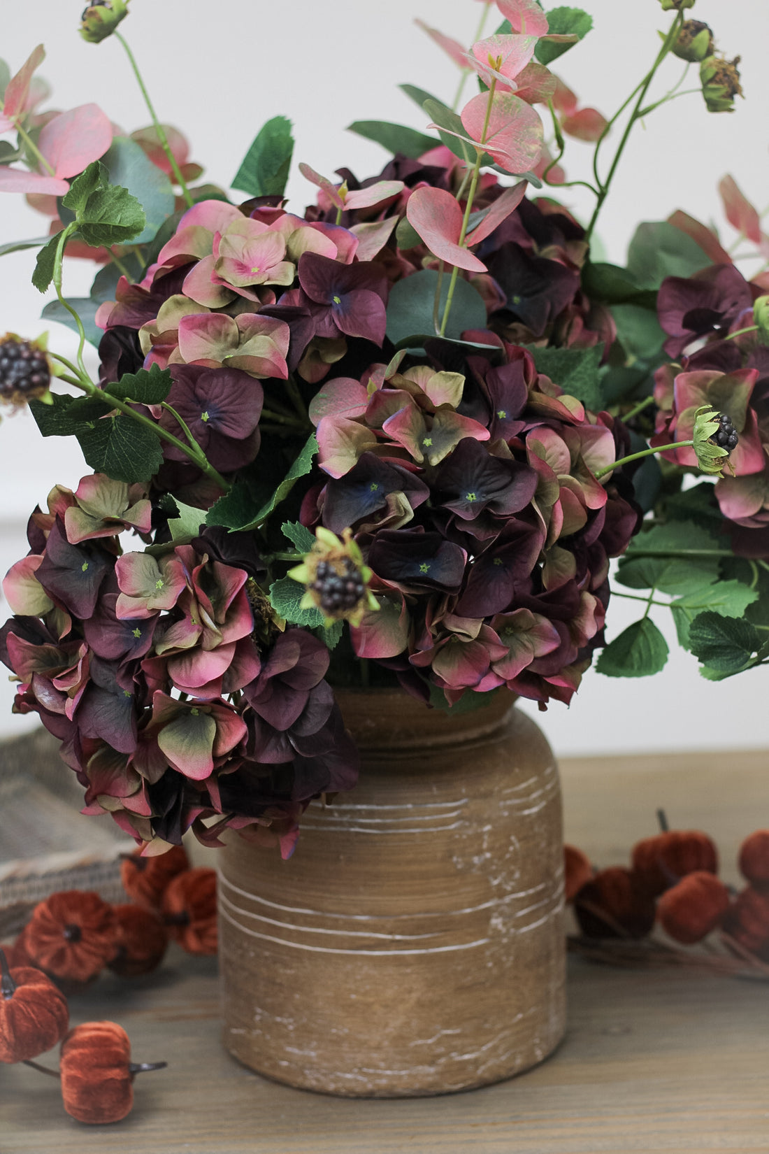 Faux autumn arrangement in rustic brown vase