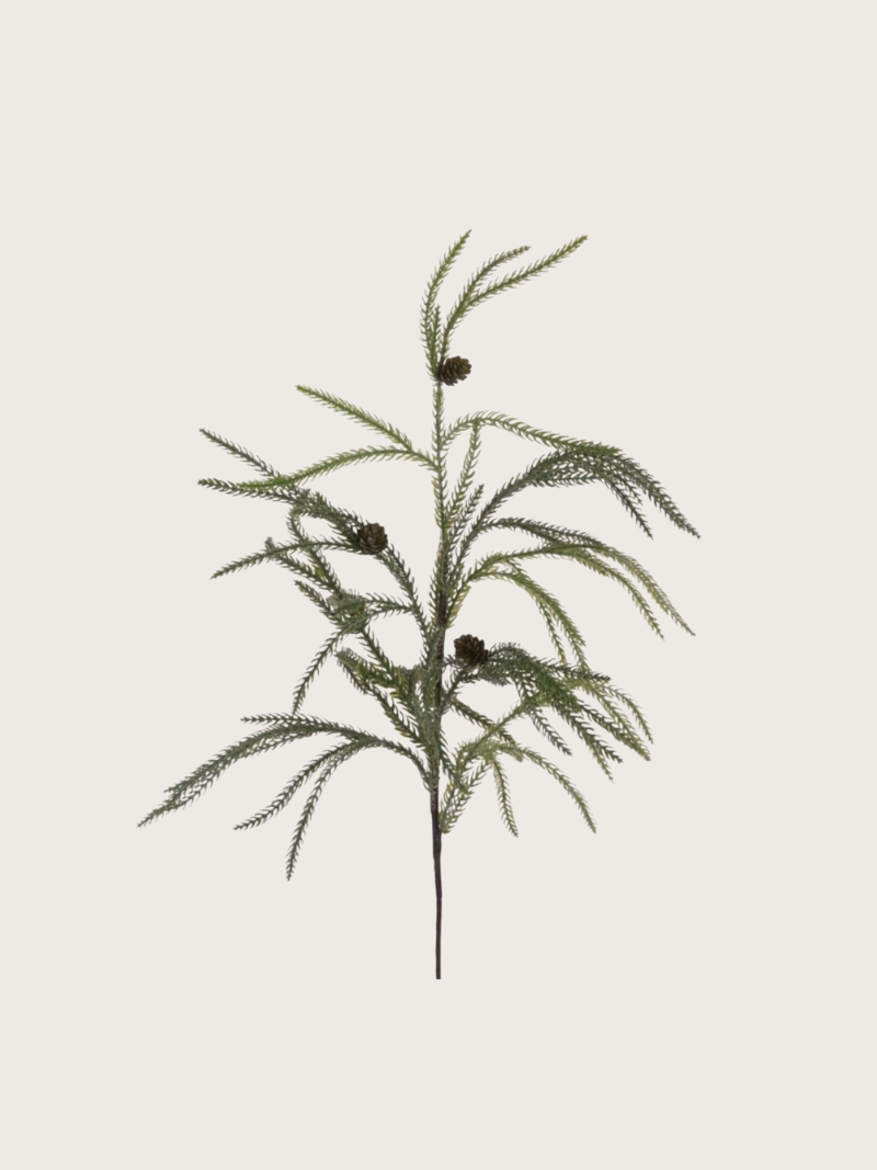Artificial plant branch with green leaves on a light gray background