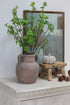 Decorative setting with a vase, Faux Green Enkianthus Spray and small pumpkin on a surface.