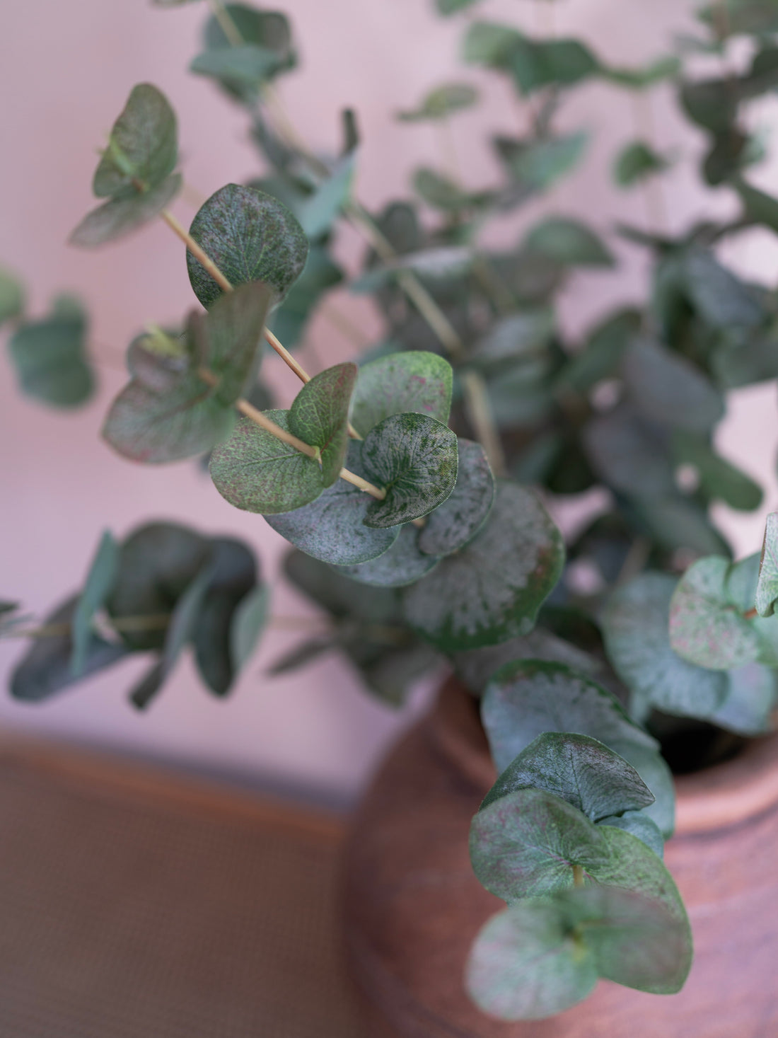Close-up of a faux green eucalyptus plant with a blurred background