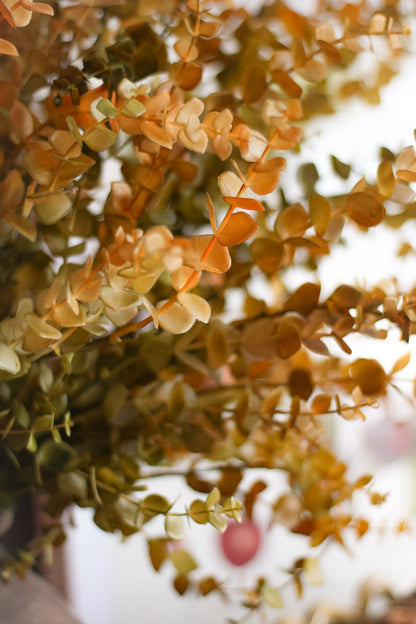 Close-up of faux green and orange leaves with a blurred background