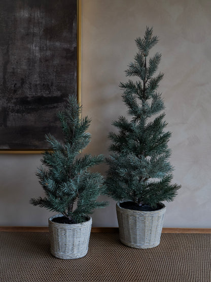 Two potted artificial christmas  trees against a neutral wall.
