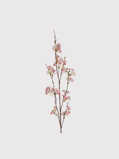 Artificial cherry blossom branch with pink flowers on a light gray background