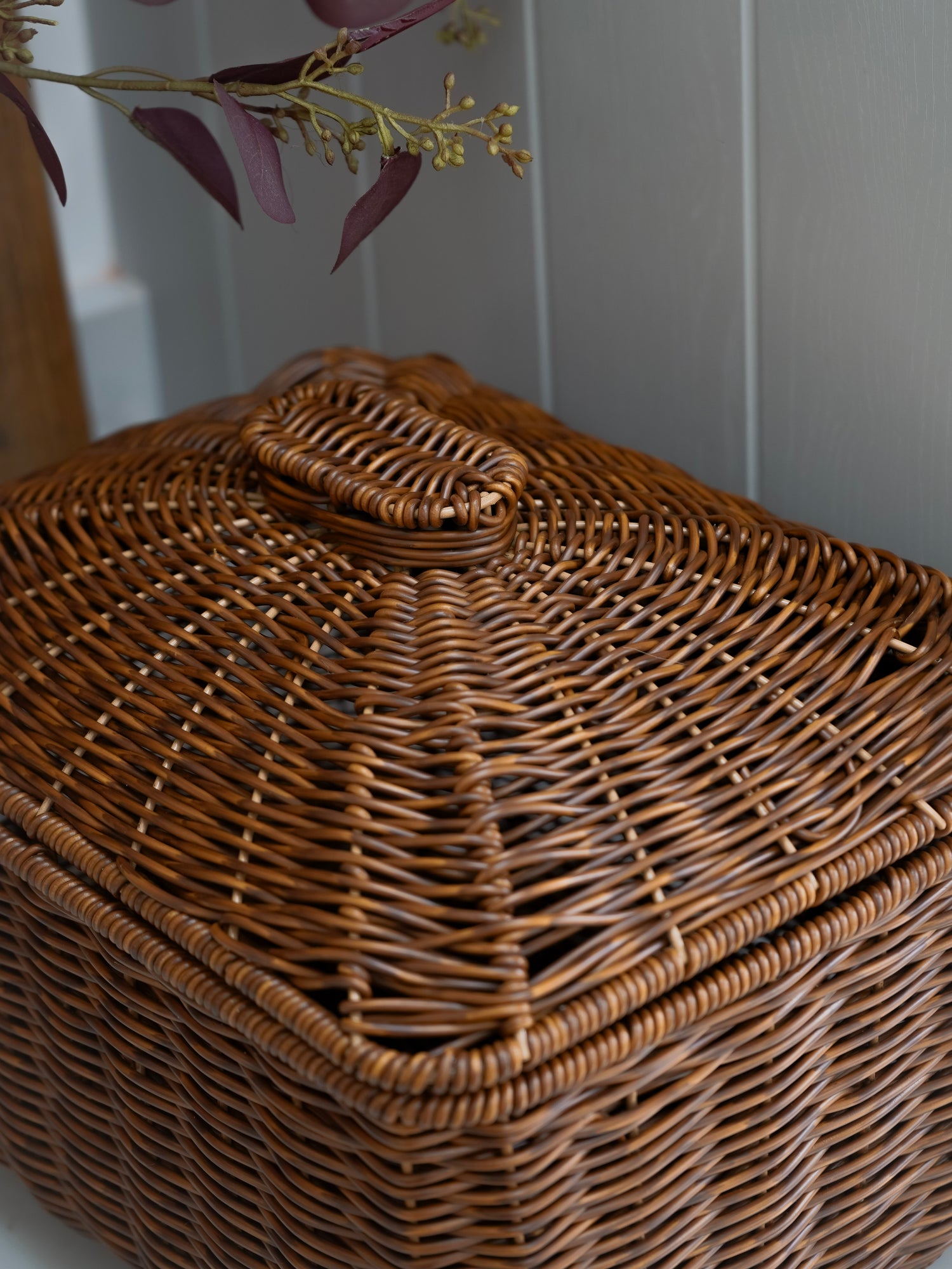 Wicker basket with a lid on a neutral background