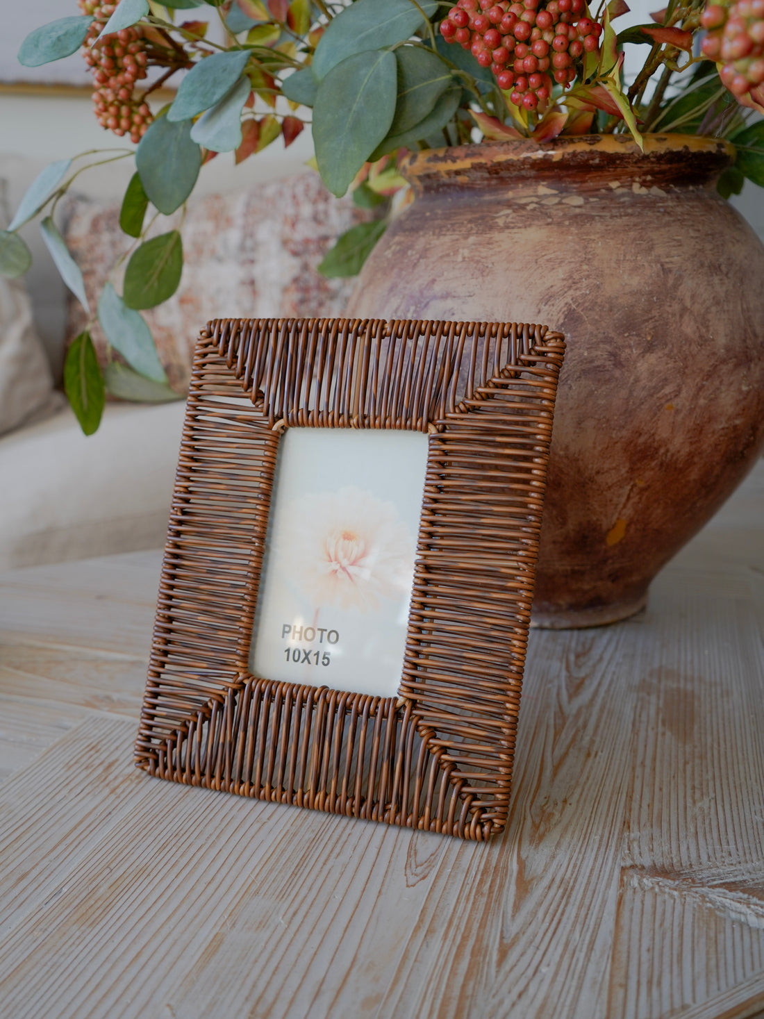 Wicker picture frame with a floral arrangement in the background