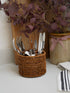 Wicker basket with cutlery on a countertop with decorative elements