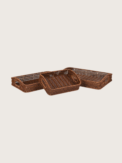 Set of three woven brown trays on a light beige background