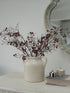 Faux Red Berries Branch in white ceramic vase with handles