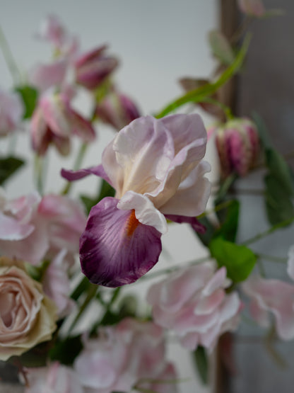 Close-up of a bouquet with faux pink and purple flowers on a blurred background