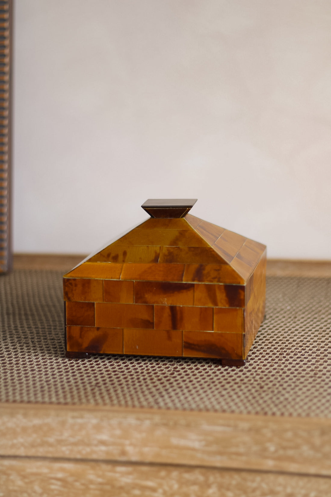 Rectangular wooden box with a textured surface on a wooden surface.