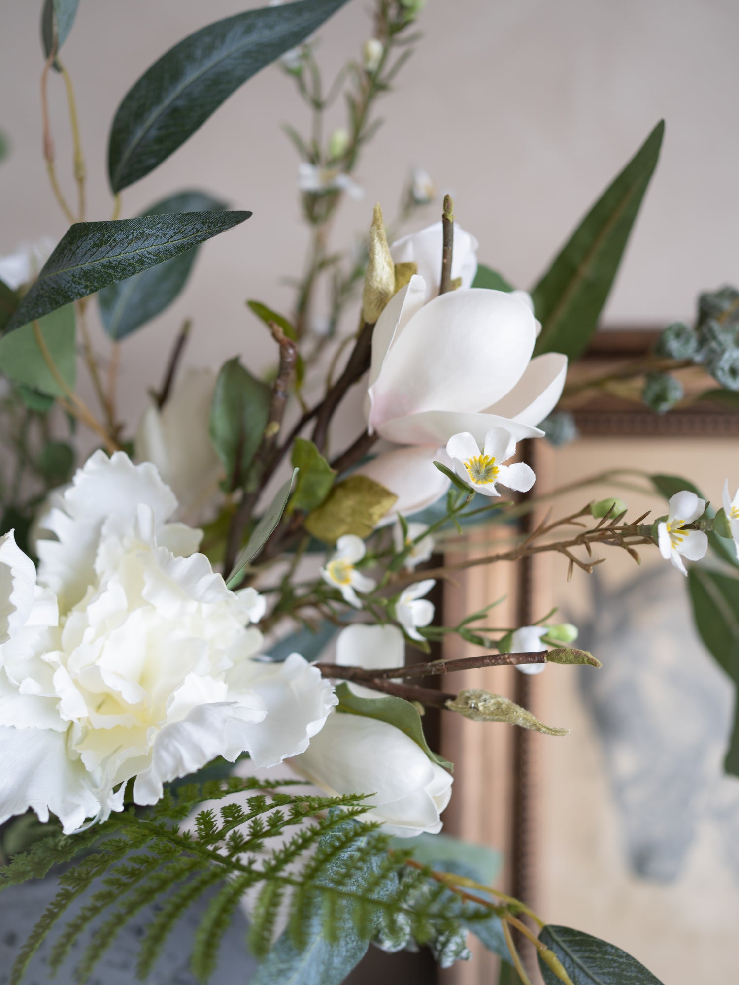 Artificial flowers and greenery arranged in a decorative setting.