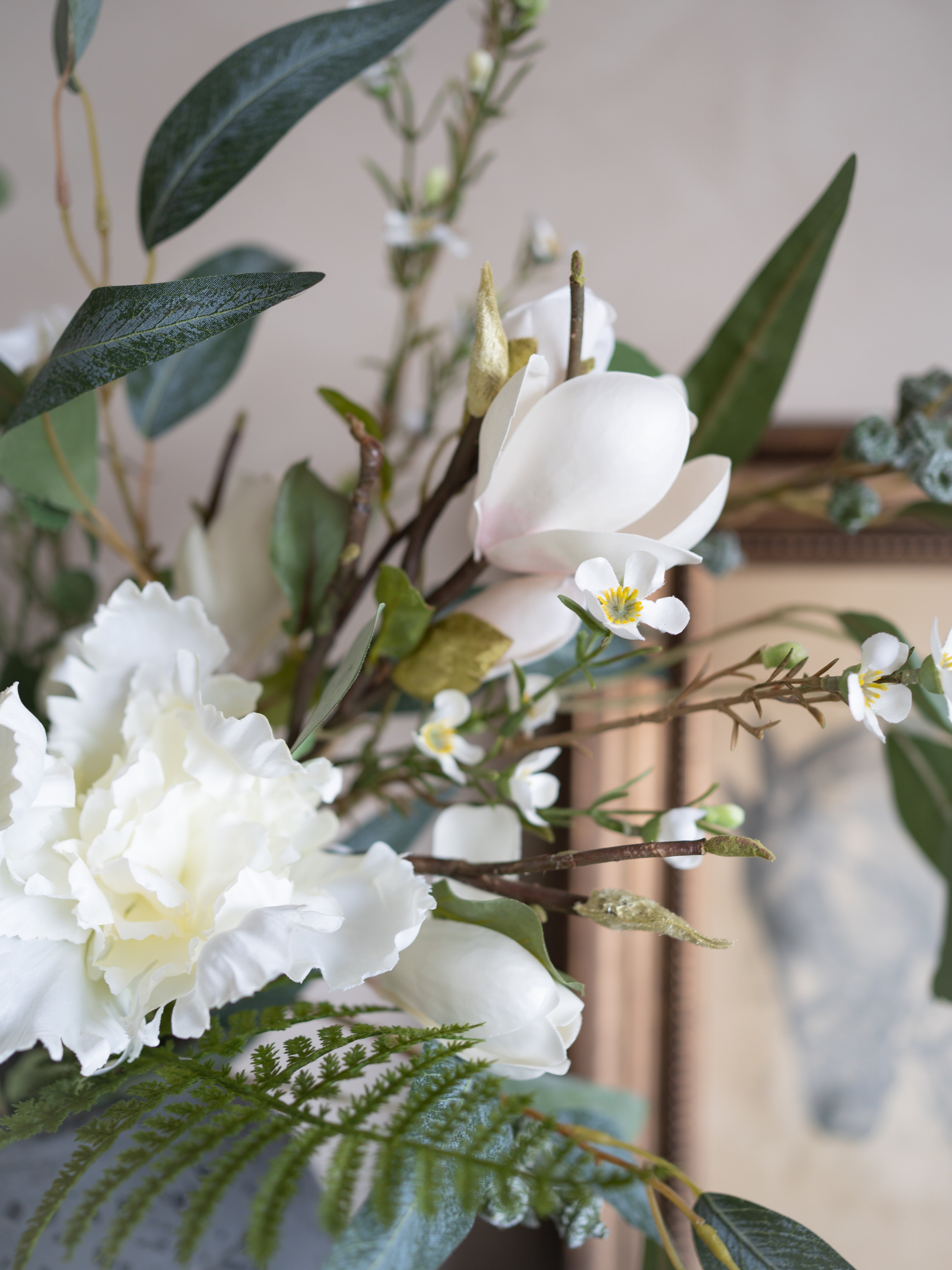 Artificial flowers and greenery arranged in a decorative setting.