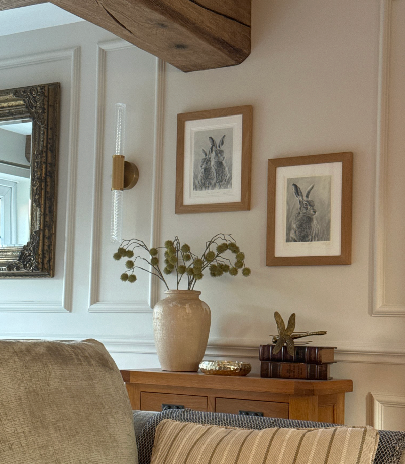 Living room with a sofa, decorative vase, and framed pictures on the wall.