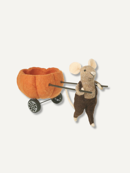 A felt mouse wearing brown pants and holding a small orange pumpkin-shaped basket on wheels, photographed on a plain light background.