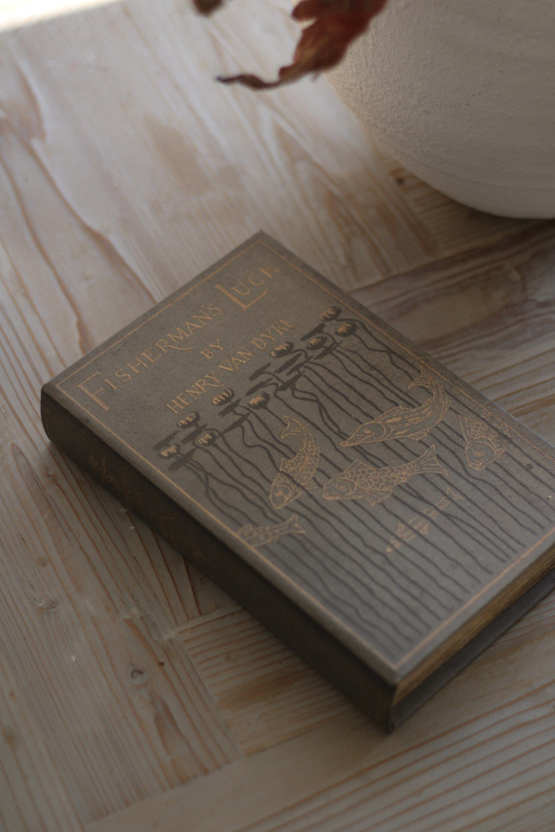 Small book with decorative cover on a wooden surface