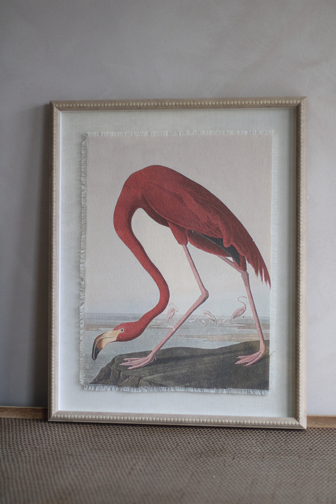 Framed artwork of a flamingo on a neutral wall.