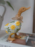 Decorative duck figurine with floral design and bow on a surface.