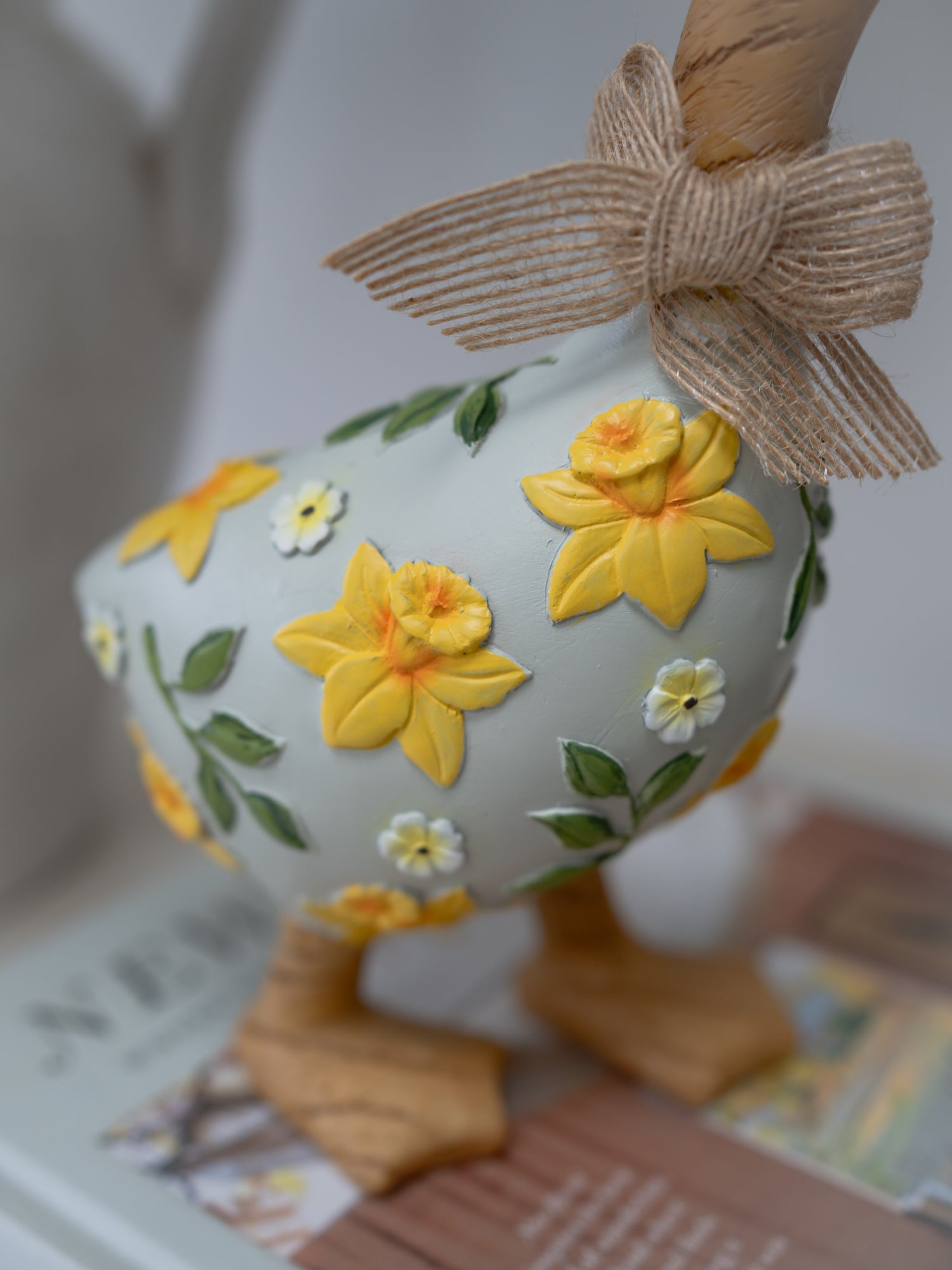 Decorative Easter egg with floral design and bow on a blurred background