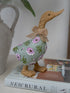 Decorative duck figurine with floral pattern and bow on a book