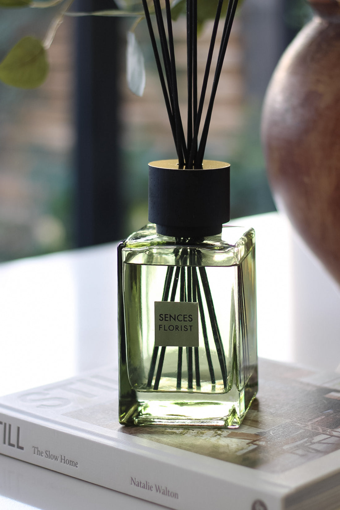 Senses Florist diffuser bottle on a book with blurred background