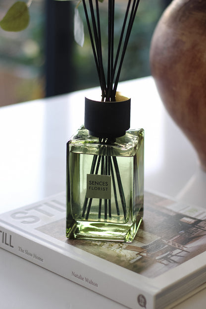 Scented diffuser bottle with black sticks on a book