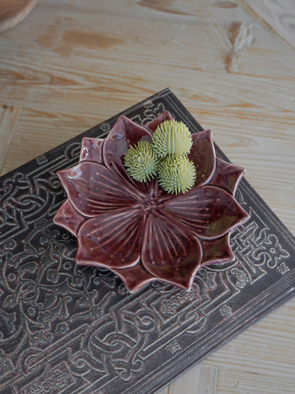 Ceramic trinket dish with green succulents on a textured surface
