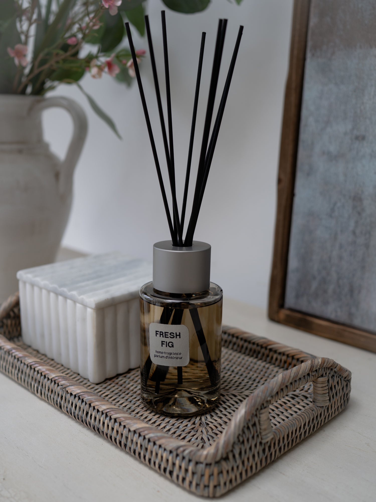 Diffuser with black sticks on a tray in a home setting