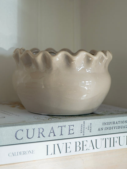 Beige ceramic bowl on top of books with visible text
