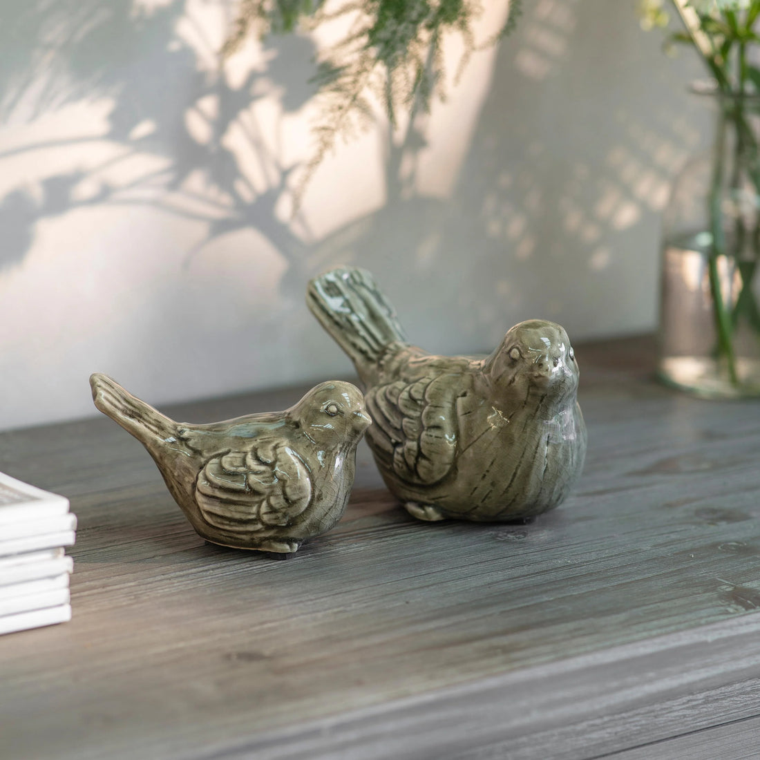 Two ceramic bird figurines on a wooden surface with a blurred background, beautiful timeless gift idea
