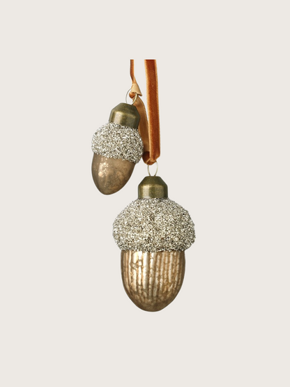Decorative acorn-shaped ornaments with glittery caps on a white background