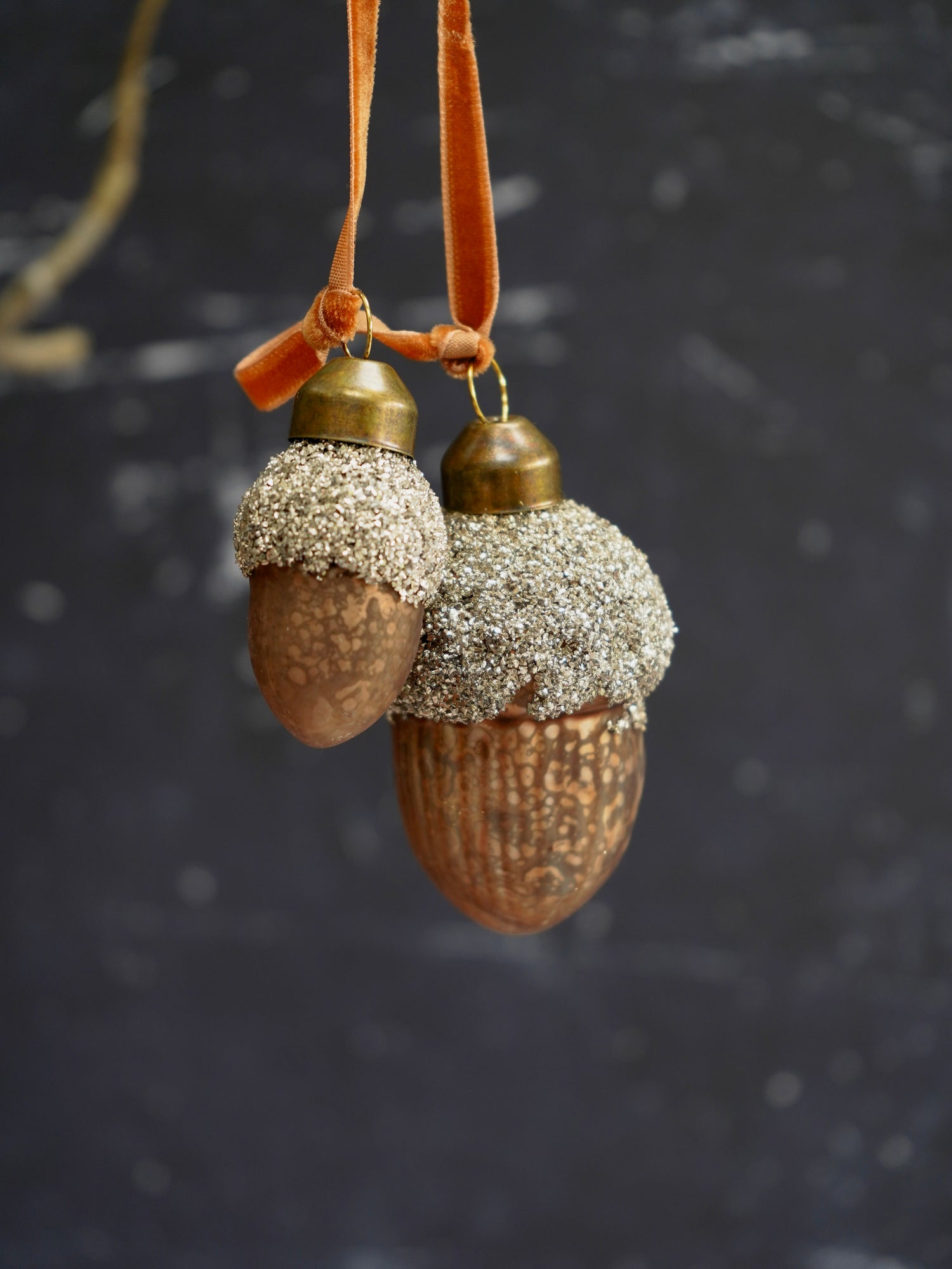 Decorative acorn ornament with glittery caps on a dark background
