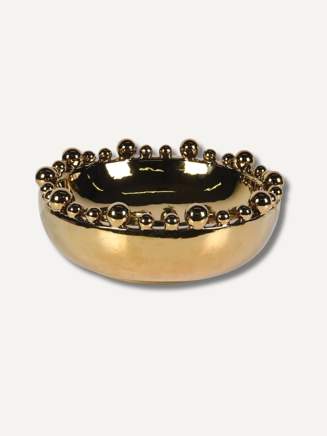 Gold decorative bowl with bobble-like embellishments on a white background
